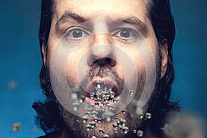 Man with open mouth exhaling or inhaling plastic particles. Environmental pollution and drug ingestion concept photo