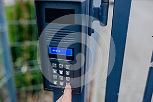 Man opening automatic property gate with security code