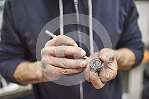 Man opening a bicycle bearing as part of a bike maintenance service