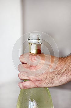 Man is opening a bottle of champagne. Waiter opens a bottle of wine. Man hands open bottle of champagne alcohol and wine drink.