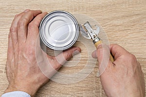 Man opening a can with a can opener