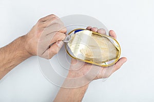 Man opening canned fish. White packed meat