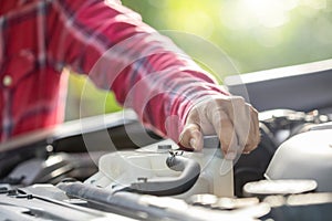 Man opening cap of car radiator to checking up the engine before start the trip. Car maintenance or check up concept