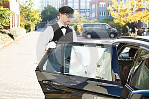 Man opening car door while woman sitting in car