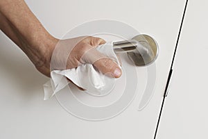 Man opening a door using a disinfecting wipe