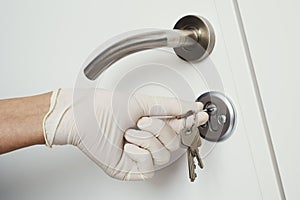 Man opening a door wearing latex gloves