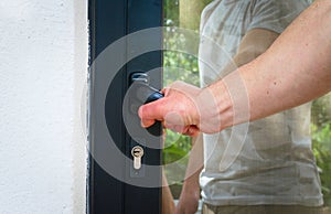 Man opening a house door. Close up. Home security, protection concept