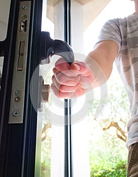 Man opening a house door. Close up. Home security, protection concept