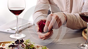 Man opening jewelry box with wedding ring, making unexpected proposal during date in cafe, close up shot