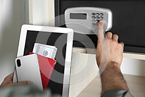 Man opening steel safe with electronic lock at hotel, closeup