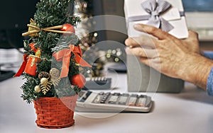 Man opening a surprise gift box on working place on the New Year eve