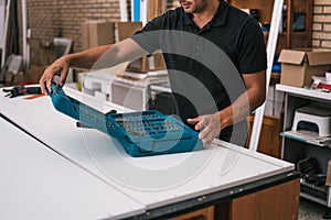 Man opening a toolbox in a furniture construction workshop