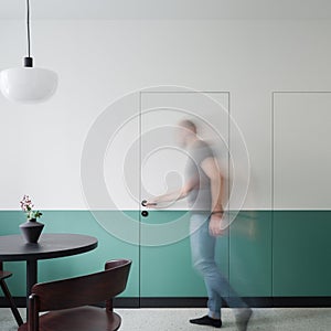 Man opening white and green doors in dining room