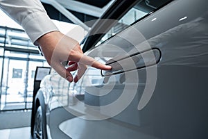 A man opens a car door with a fingerprint. Integrated handle.