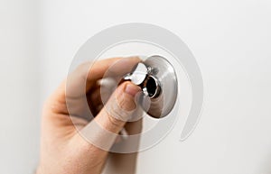 Man opens the door peephole