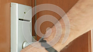 A man opens a hotel room with a card key. Close-up