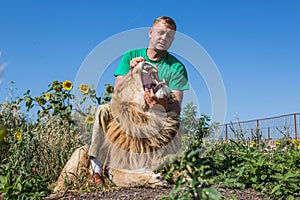 The man opens the jaws of a lion in safari park Taigan, Crimea,