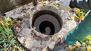 Man opens a septic tank hatch in the yard, 4K video