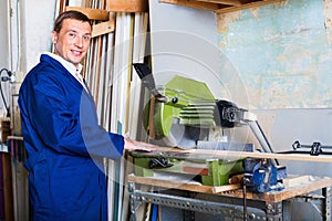 Man operating circular saw in wood workshop