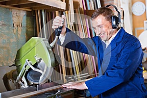 Man operating circular saw in wood workshop