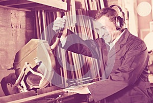 Man operating circular saw in wood workshop