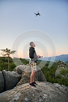 Man operating drone using remote controller.