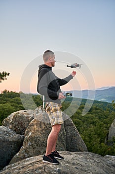 Man operating drone using remote controller.
