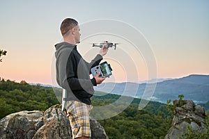 Man operating drone using remote controller.