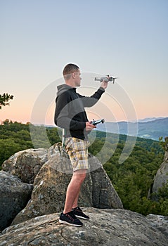 Man operating drone using remote controller.