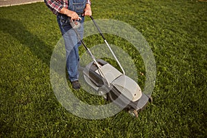 Man operating a lawn mower while trimming the grass