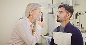 Man at the optometrist doing an eye exam to check his eyesight. Indian male at a checkup with an opthalmologist to