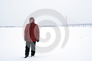 The man in the orange jacket on a winter day in the field