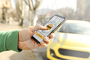 Man ordering taxi with smartphone on street, closeup