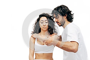 Man osteopath doing shoulder blade therapy on young woman