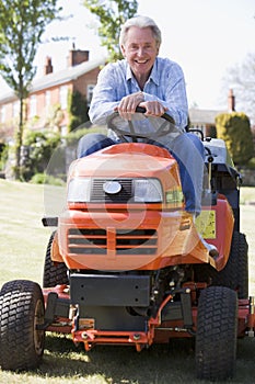 Man outdoors on lawnmower smiling