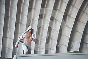 The man outdoors practices parkour, extreme acrobatics.