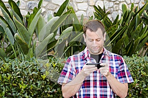 Man outside playing on a smart phone.