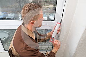Man In Overall Applying Silicone Sealant