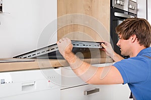 Man In Overall Installing Induction Stove