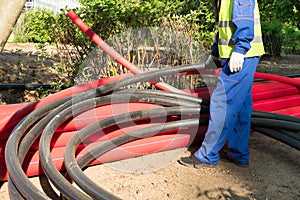 A man in overalls counts large plastic pipes