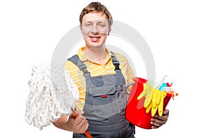 Man in overalls holding a mop and cleaning products