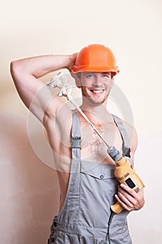 Man in overalls with a mixer for plastering