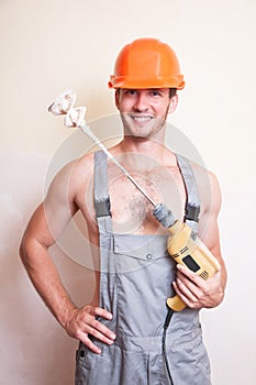 Man in overalls with a mixer for plastering