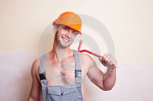 Man in overalls with a tool for dismantling