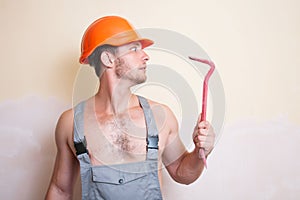 Man in overalls with a tool for dismantling