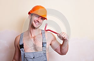 Man in overalls with a tool for dismantling