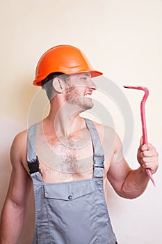 Man in overalls with a tool for dismantling