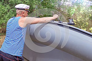 The man overturns the rubber boat. Care and maintenance of an inflatable boat. Preparation for fishing and rest