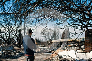 Man owner checking ruins after fire disaster.