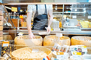 Man packing cheese in the shop